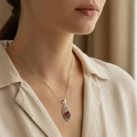 model wearing silver pendant with 5x7 mm oval garnet