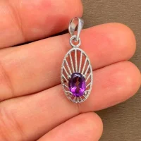 silver pendant with 5x7 mm oval amethyst displayed on hand