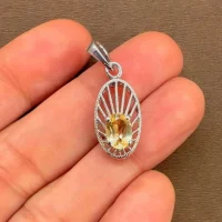 silver pendant with 5x7 mm oval citrine displayed on hand