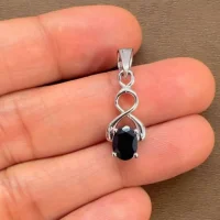 silver pendant with 5x7 mm oval black onyx displayed on hand