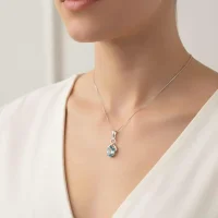 model wearing silver pendant with 5x7 mm oval blue topaz