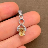 silver pendant with 5x7 mm oval citrine displayed on hand