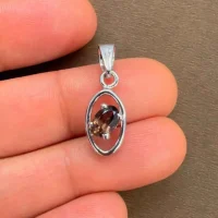 silver pendant with 6x4 mm oval smoky quartz displayed on hand