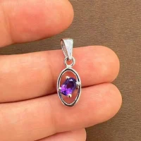 silver pendant with 6x4 mm oval amethyst displayed on hand