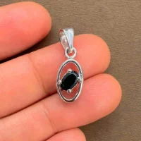 silver pendant with 6x4 mm oval black onyx displayed on hand