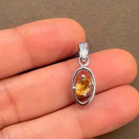 silver pendant with 6x4 mm oval citrine displayed on hand