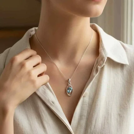 model wearing silver pendant with 6x4 mm oval Blue Topaz