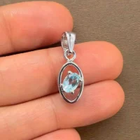 silver pendant with 6x4 mm oval Blue Topaz displayed on hand