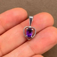 silver pendant heart shaped with 6x4 mm oval amethyst displayed on hand