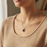 model wearing silver pendant heart shaped with 6x4 mm oval black onyx