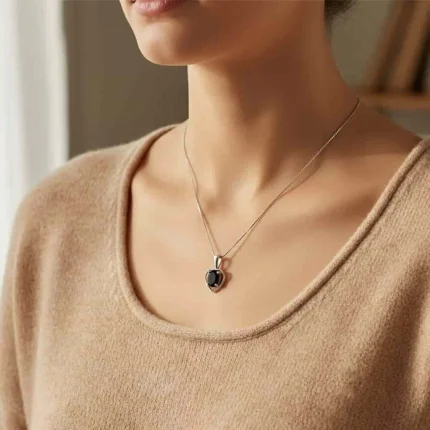 model wearing silver pendant heart shaped with 6x4 mm oval black onyx