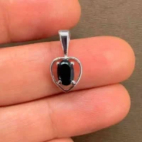 silver pendant heart shaped with 6x4 mm oval black onyx displayed on hand