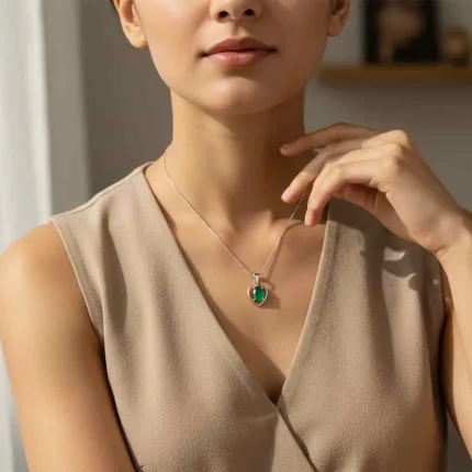model wearing silver pendant heart shaped with 6x4 mm oval green onyx