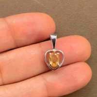 silver pendant heart shaped with 6x4 mm oval citrine displayed on hand