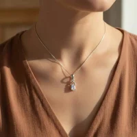model wearing silver pendant with 6x4 mm pear rainbow moonstone