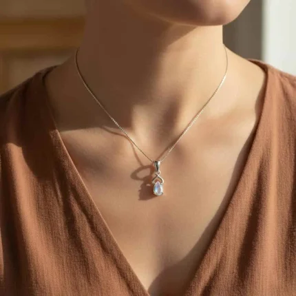 model wearing silver pendant with 6x4 mm pear rainbow moonstone