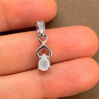 silver pendant with 6x4 mm pear rainbow moonstone displayed on hand