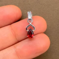 silver pendant with 6x4 mm pear garnet displayed on hand