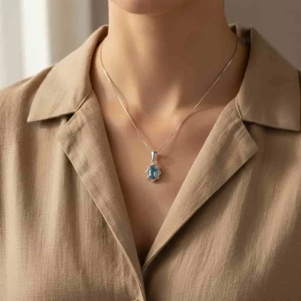 model wearing silver pendant with 6x4 mm oval swiss blue topaz