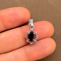 silver pendant with 6x4 mm oval black onyx displayed on hand