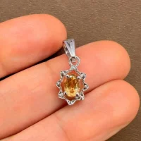 silver pendant with 6x4 mm oval citrine displayed on hand