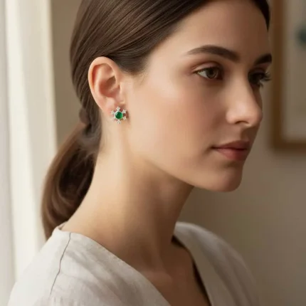 model wearing silver studs snowflake design with 5 mm round green onyx in band setting and cubic zirconia in prong setting