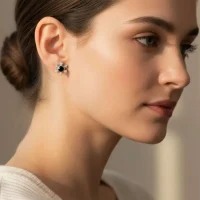 model wearing silver studs snowflake design with 5 mm round black onyx in band setting and cubic zirconia in prong setting