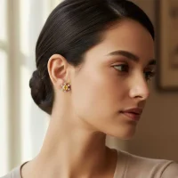 model wearing silver studs snowflake design with 5 mm round citrine in band setting and cubic zirconia in prong setting