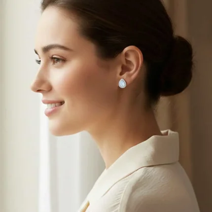 model wearing silver studs cluster with 7x5 mm pear Rainbow Moonstone and cubic zirconia