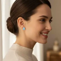 model wearing silver studs cluster with 7x5 mm pear blue topaz and cubic zirconia