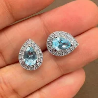 silver studs cluster with 7x5 mm pear blue topaz and cubic zirconia displayed on hand
