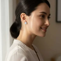 model wearing silver studs with 7x9 mm oval Rainbow Moonstone and cubic zirconia