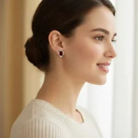 model wearing silver studs with 7x9 mm oval Garnet and cubic zirconia
