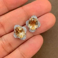 silver studs with 7x9 mm oval Citrine and cubic zirconia displayed on hand