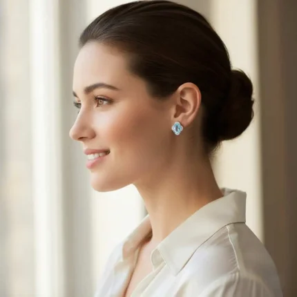 model wearing silver studs with 7x9 mm oval Blue Topaz and cubic zirconia