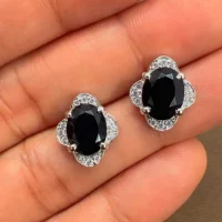 silver studs with 7x9 mm oval Black Onyx and cubic zirconia displayed on hand