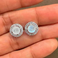 silver studs cluster with 6mm round Rainbow Moonstone and cubic zirconia displayed on hand