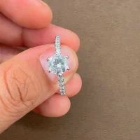 Silver Ring Solitaire with 6mm round shaped Cubic Zirconia and small round Cubic Zirconia displayed on hand