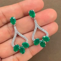 Silver Earrings with 5x7 mm oval shaped Green Onyx Gemstone and Cubic Zirconia displayed on hand