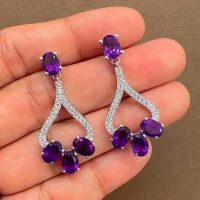 5x7 mm oval shaped Amethyst Gemstone and Cubic Zirconia displayed on hand