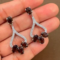 5x7 mm oval shaped Smoky Quartz Gemstone and Cubic Zirconia displayed on hand