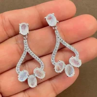 5x7 mm oval shaped Rainbow moonstone Gemstone and Cubic Zirconia displayed on hand