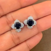 Silver Studs flower shaped with 6mm round shaped Black Onyx Gemstone and Cubic Zirconia displayed on hand