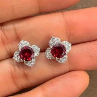 Silver Studs flower shaped with 6mm round shaped Garnet Gemstone and Cubic Zirconia displayed on hand