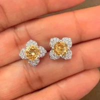 Silver Studs flower shaped with 6mm round shaped Citrine Gemstone and Cubic Zirconia displayed on hand