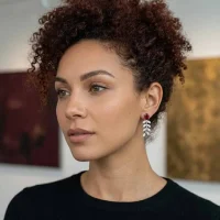 model wearing silver earrings gemstones with 5x7 mm oval garnet