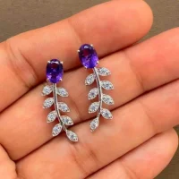 silver earrings gemstones with 5x7 mm oval amethyst displayed on hand