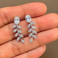 silver earrings gemstones with 5x7 mm oval cubic zirconia displayed on hand