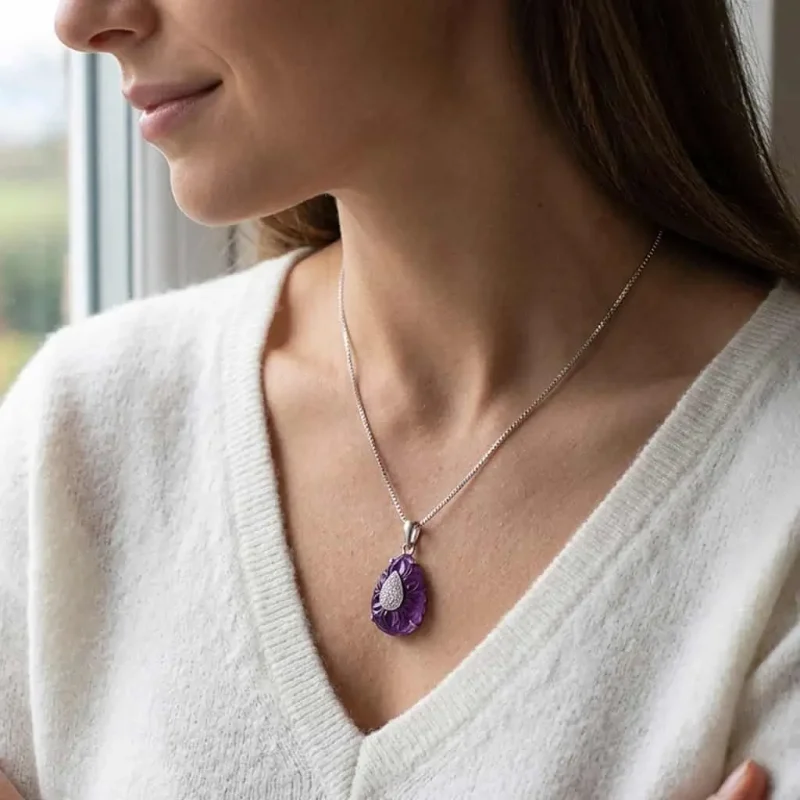 model wearing silver carved gemstone pendant with pear shaped african amethyst and cubic zirconia