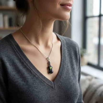model wearing silver carved gemstone pendant with guitar shaped black onyx and peridot